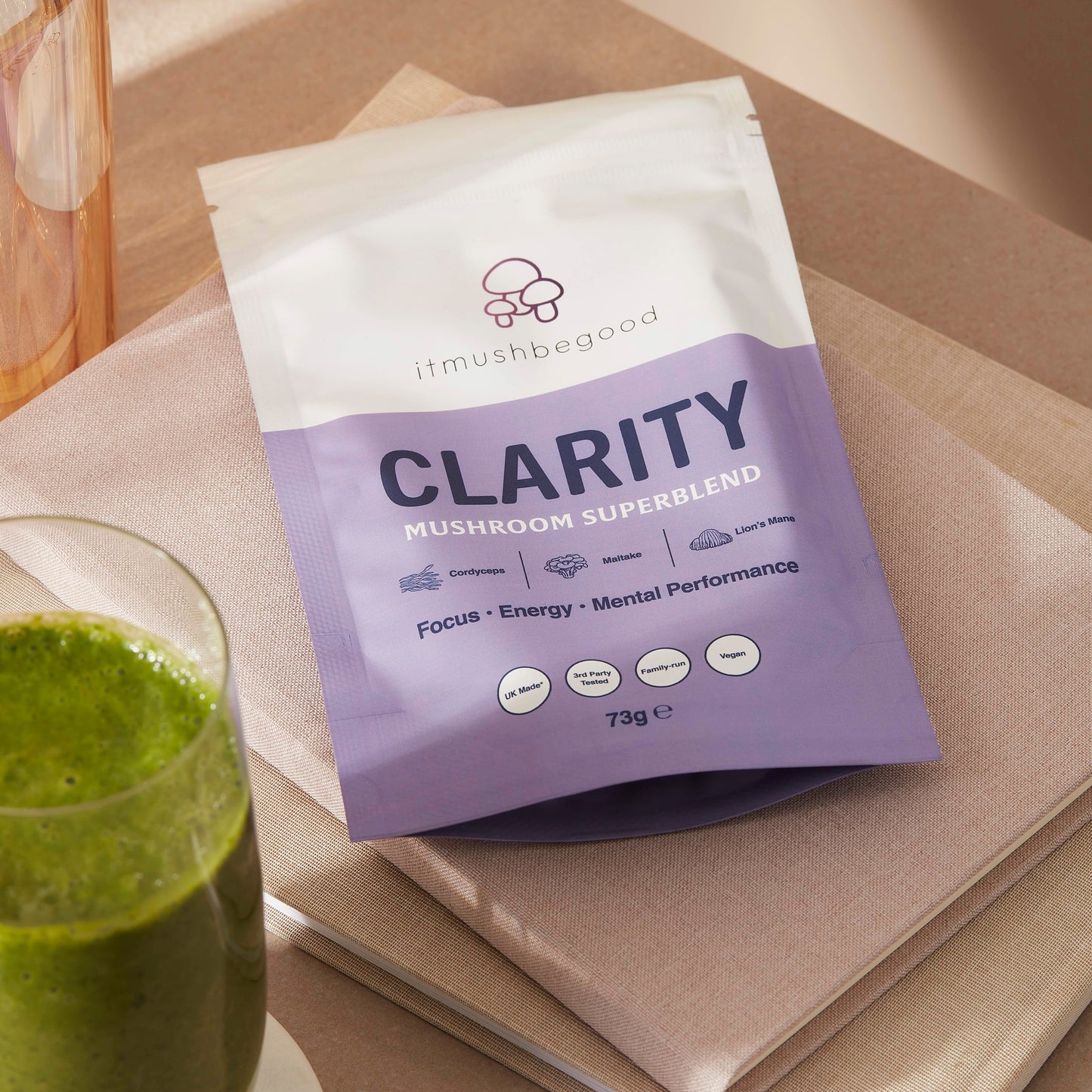 Clarity Packet laying down on notebooks next to a smoothie