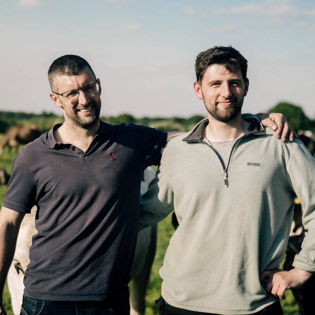 Two of our staff members standing in a sunny field.